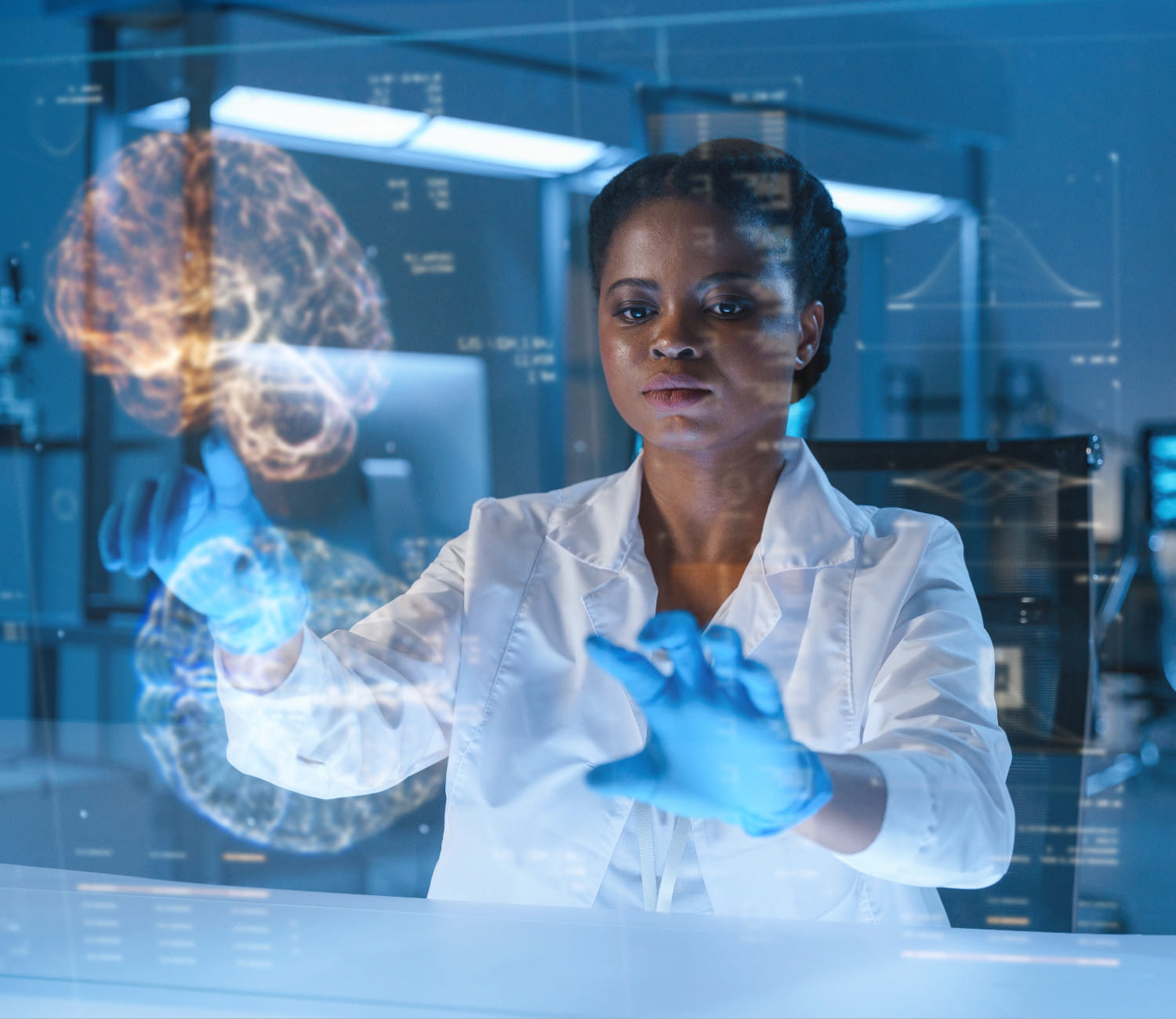 Young African-American doctor in a lab with a dark illumination in a lab coat and protective gloves works late with a HUD screen with a brain projection in a futuristic laboratory.